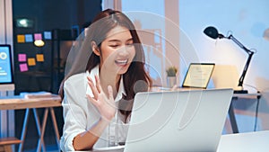 Young Asian business woman on video conference call, using laptop computer work late night. Remote meeting, work at home