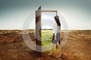 Young asian business woman walking to the open door going to green environment