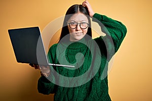 Young asian business woman wearing glasses and working using computer laptop confuse and wondering about question