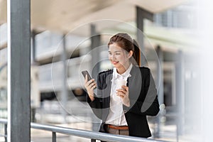 Young Asian business woman wearing suit using application on cell phone, read news on smartphone, fast connection