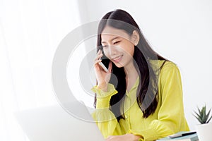 Young asian business woman working form home office and call phone for success at home.