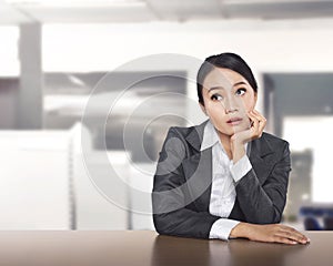 Young asian business woman working at office desk and thinking s