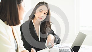 Young Asian business women auditor pay attention to listening her colleague talking and tell about the company transaction with