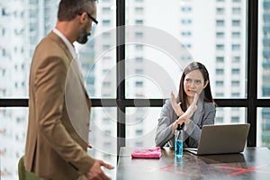 Young asian business woman forced young businessmen to sit with Because of having to prevent communicable diseases photo