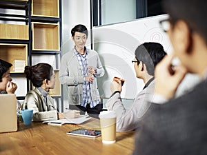 Young asian businessman facilitating a discussion photo