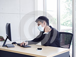 Young Asian businessman pain while using notebook computer in office