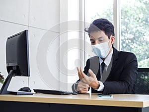 Young Asian businessman pain while using notebook computer in office