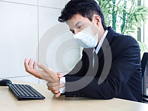 Young Asian businessman pain while using notebook computer in office