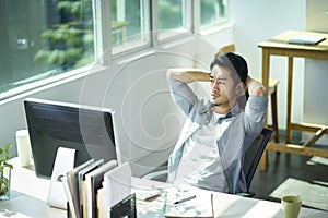 Young asian businessman thinking in office
