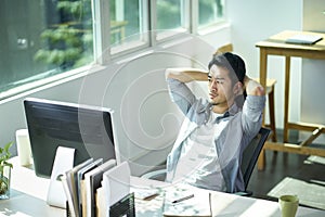 Young asian businessman thinking in office photo