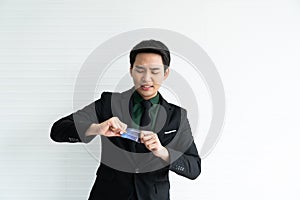 Young asian businessman try to  destroy credit card on white background / business concept / payment and expense concept /