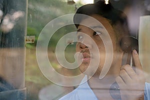 Young Asian businessman using the payphone outdoors