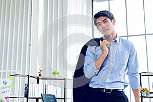 Young Asian Businessperson is standing smart poses and smile at co working space decorated in modern office style for startup