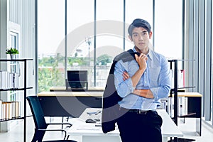 Young Asian Businessperson is standing smart poses and smile at co working space decorated in modern office style for startup