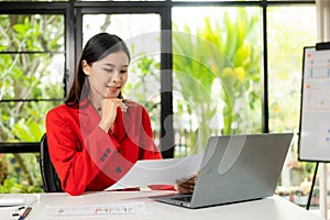 Young Asian businesswoman calculating tax invoice, loan interest rate, law firm, entrepreneur using financial