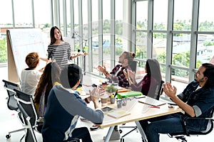 Young asian businesswoman explain idea to group of creative diverse team at modern office.