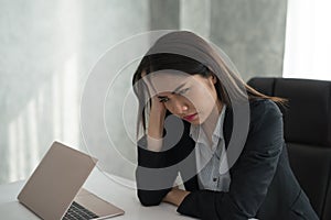 Young asian businesswoman feel stressed/worry/headache/disappoint during working while sit at office