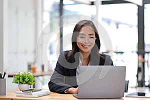 Young Asian businesswoman is happy to work at the modern office using a tablet.