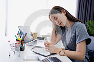 Young Asian businesswoman has a headache. She wants to relax