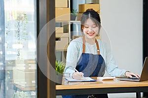 Young asian businesswoman onwer checking parcels list before delivering to customers.