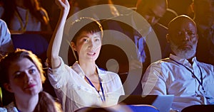 Young Asian businesswoman raising hand in business seminar at auditorium 4k