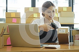 Young asian businesswoman use bar code scanner Scan the barcode on the product box.