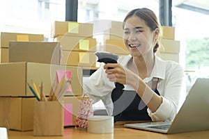 Young asian businesswoman use bar code scanner Scan the barcode on the product box.