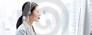 Young Asian businesswoman wearing headsets working as a customer service operator in call center