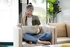 Young asian businesswoman working at office using mobile phone..