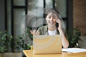 Young asian businesswoman working at office using mobile phone..