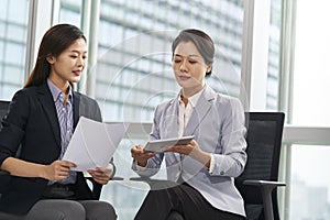 young asian businesswomen discussing business in office using digital tablet