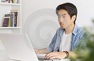 Young Asian Casual Businessman Working with Laptop in Home Office