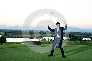 Young Asian CEO Businessman wearing suite playing golf at the golf course. Portrait of Asian businessman joying to success