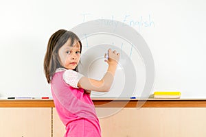 Young Asian child writing on a whiteboard