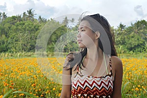 Young Asian Chinese tourist woman enjoying relaxed the view of a beautiful flowers field landscape during a journey excursion in h