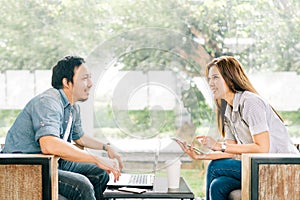 Young Asian couple or coworker talking at coffee shop or modern office photo