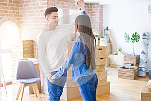 Young asian couple dancing and smiling celebrating moving to a new home