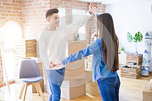 Young asian couple dancing and smiling celebrating moving to a new home