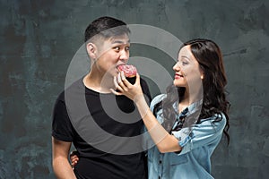 Young asian couple enjoy eating of sweet colorful donut