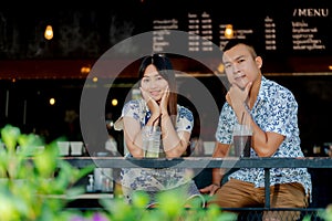 A young Asian couple enjoying coffee in a coffee shop in a tourist attraction