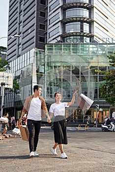 Young Asian couple going out for shopping on Le Loi road in Hochiminh city, Vietnam photo