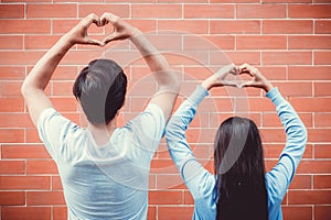 Young asian couple happy in love with gesture hand heart shape.