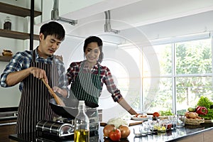 Young Asian couple are happy to cook together