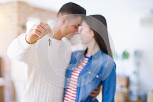Young asian couple holding keys of new house, smiling happy and excited moving to a new apartment