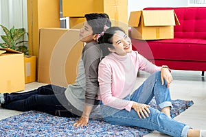 Young Asian couple lovers move the cardboard boxes to new family house