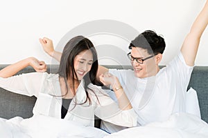 Young asian couple love man and woman woke up in morning on the bed and happy moment