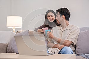 Young Asian couple in love Sitting and relaxing together in the living room happily. Couple making romantic love in the