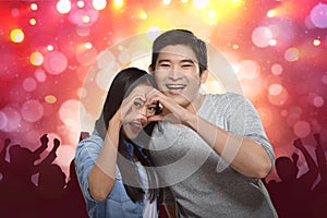 Young asian couple making heart shape with hands