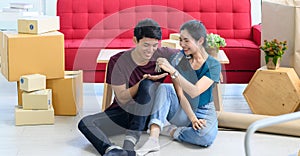 Young Asian couple move into new apartment on Moving Day, celebrating moving to new home concept