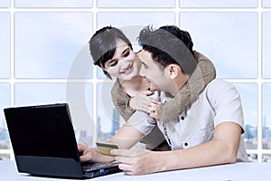 Young asian couple online shopping at appartment